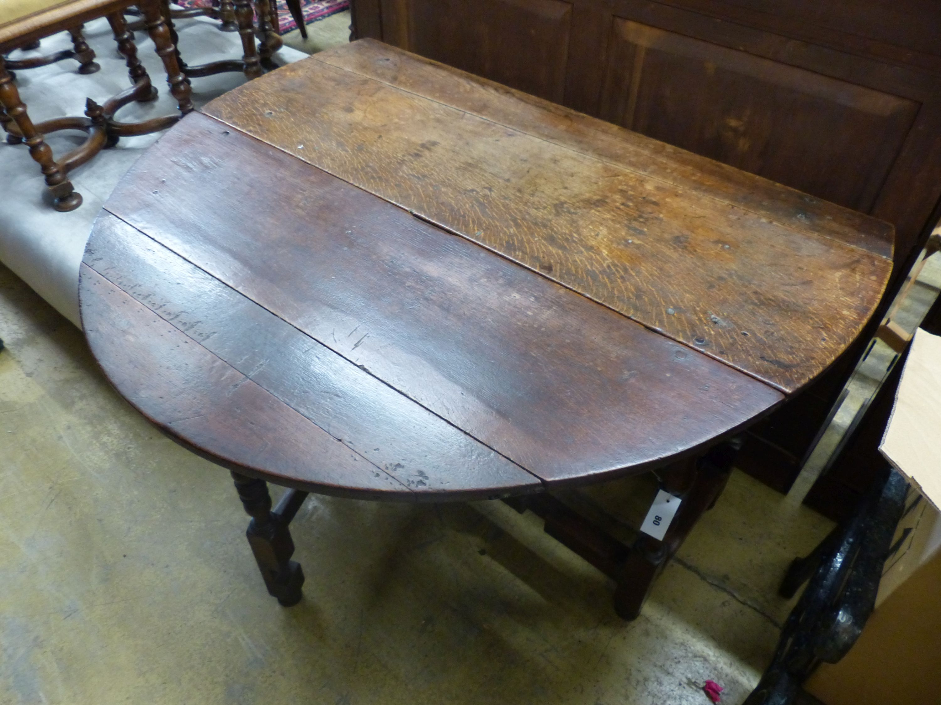 An 18th century oval oak gateleg dining table, length 135cm extended, width 114cm, height 75cm